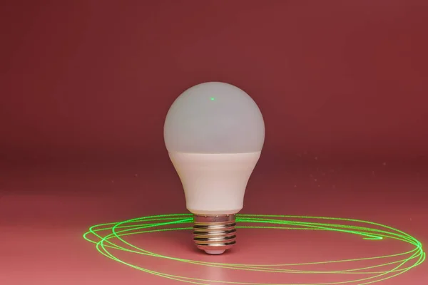 Lampadina a risparmio energetico, raggio laser verde intorno, spazio di copia. Idea minimale . — Foto Stock