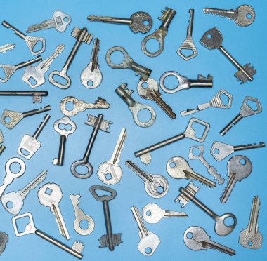 Anahtarlar mavi arka plan üzerine ayarlanır. Kapı kilit anahtarları ve mülkiyet güvenliği ve ev koruması için kasalar. Farklı antika ve yeni anahtar türleri.