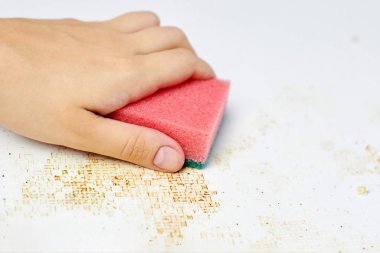 Kadın elinin süngeri kiri, ekmek kırıntılarını ve artıkları temizler. Mutfak masasını temizliyorum. Ev işleri.
