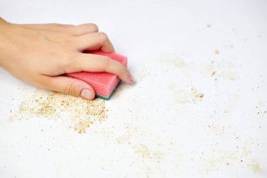 Kadın elinin süngeri kiri, ekmek kırıntılarını ve artıkları temizler. Mutfak masasını temizliyorum. Ev işleri.