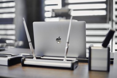 Modern ofis işyeri. İş yerinde şef, patron ya da diğer çalışanlar için iş bilgisayarı var. Defter çalışma masasında. Açık panjurların yarısından geçen ışık - 2019.07.07 - Rusya, Nizhny Novgorod