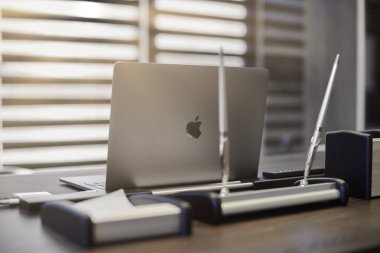 Modern ofis işyeri. İş yerinde şef, patron ya da diğer çalışanlar için iş bilgisayarı var. Defter çalışma masasında. Açık panjurların yarısından geçen ışık - 2019.07.07 - Rusya, Nizhny Novgorod