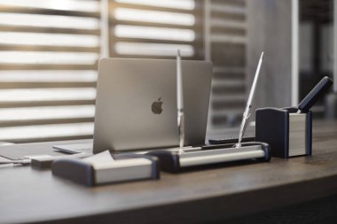 Modern ofis işyeri. İş yerinde şef, patron ya da diğer çalışanlar için iş bilgisayarı var. Defter çalışma masasında. Açık panjurların yarısından geçen ışık - 2019.07.07 - Rusya, Nizhny Novgorod