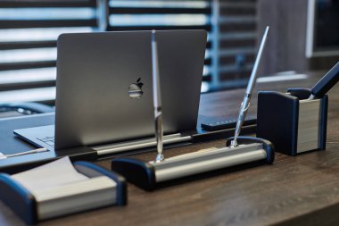 Modern ofis işyeri. İş yerinde şef, patron ya da diğer çalışanlar için iş bilgisayarı var. Defter çalışma masasında. Açık panjurların yarısından geçen ışık - 2019.07.07 - Rusya, Nizhny Novgorod