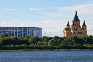 Rusya, Nizhny Novogorod - 07.07.2019 - Stadyum ve nehir kenarındaki ortodoks kilisesi. Futbol Dünya Kupası için stadyum. Nizhny Novgorod 'un tükürüğü