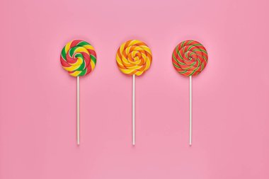 Pembe bir arka plan üzerinde tatlı lolipop