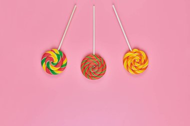 Pembe bir arka plan üzerinde tatlı lolipop
