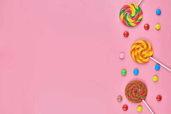 Dulces piruletas y dulces sobre fondo rosa —  Fotos de Stock