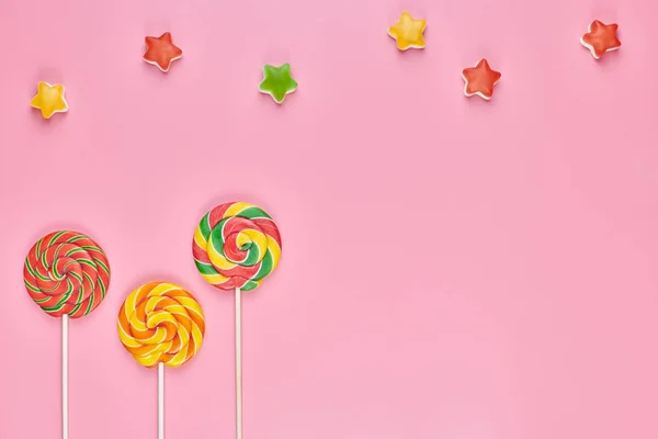 Леденцы и конфеты на розовом фоне — стоковое фото