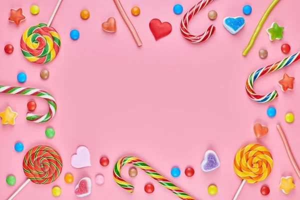 Bonbons sucrés copie espace cadre avec sucettes sur fond rose — Photo
