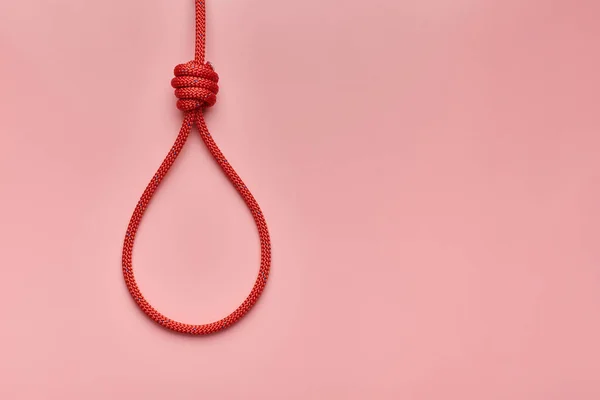 Hangman\'s knot, copy space. Incitement to suicide or death penalty concept. Red braided hanging noose tied the knot.