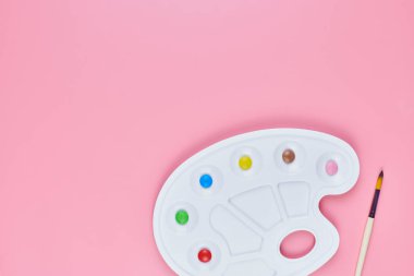 Şekerleme sanatı konsepti, kopyalama alanı. Pembe arka planda boya paletinde tatlı şekerler. Çocukluktaki renkli tatlılara ve tatlı pişirmeye bayılırım.