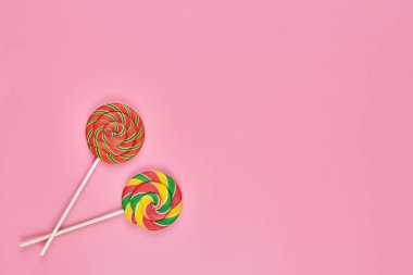 Pembe arka planda tatlı lolipoplar, kopyalama alanı. Çocukluk konseptinde renkli tatlılara bayılırım.
