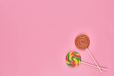 Pembe arka planda tatlı lolipoplar, kopyalama alanı. Çocukluk konseptinde renkli tatlılara bayılırım.