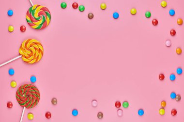 Tatlı şeker fotokopi çerçevesi ve pembe arka planda lolipoplar. Çocukluk konseptinde renkli tatlılara bayılırım.