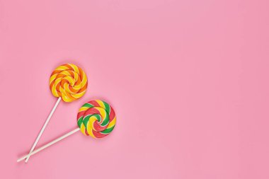 Pembe arka planda tatlı lolipoplar, kopyalama alanı. Çocukluk konseptinde renkli tatlılara bayılırım.