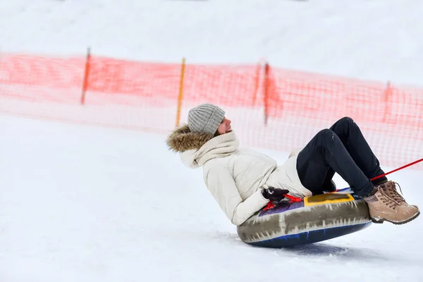 Rehetikha ロシア 2019 雪のチューブで寝ている幸せな若い女の子 子供やティーンエイジャーのための雪のチューブゲーム — ストック写真