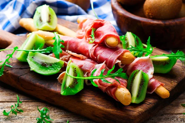 Prosciutto and kiwi.selective focus. — Stock Photo, Image