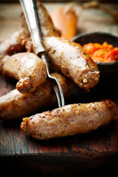 Merguez Sausages with harissa on wooden board — Stock Photo, Image