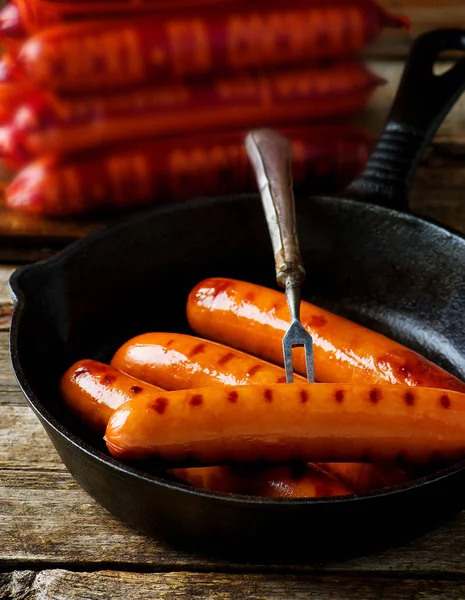 Sausages in a pig-iron frying pan. — Stock Photo, Image