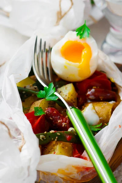 Vegetables with sausages in parchment. — Stock Photo, Image