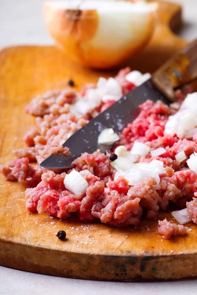 Forzar la carne con cebolla en la tabla de cortar — Foto de Stock