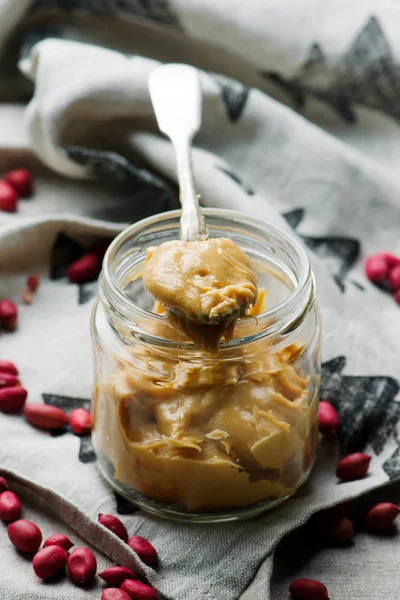 Peanut butter in to the glass jar. selective focus — Stock Photo, Image