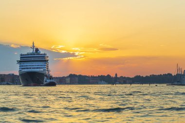 Gün doğumunda bir römorkör Venedik 'te büyük bir yolcu gemisine rehberlik eder.
