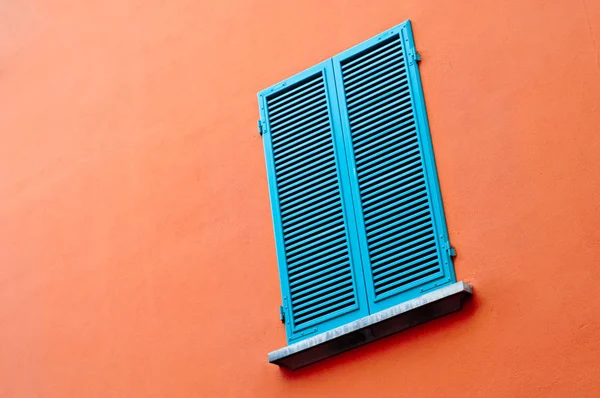 Janela azul na parede laranja — Fotografia de Stock