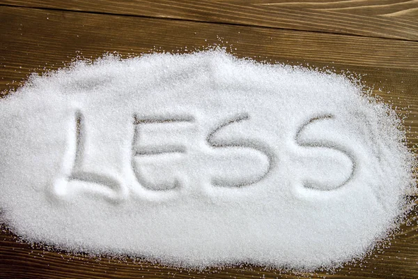 LESS written on pile of sugar — Stock Photo, Image