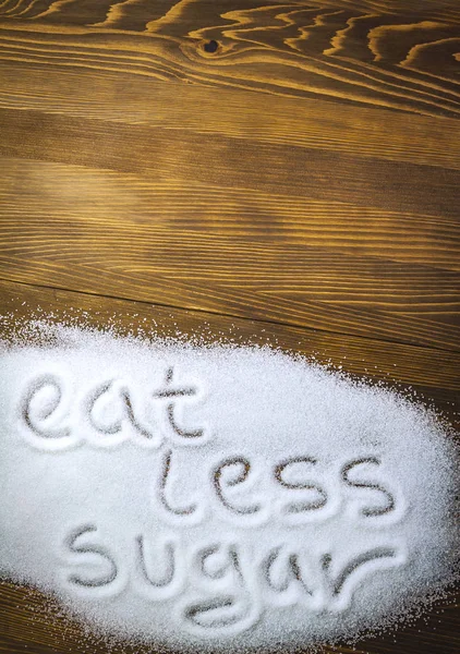 Essen Sie weniger Zucker auf einem Haufen Zucker geschrieben — Stockfoto