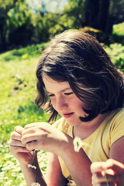 Красивая девочка-подросток играет с цветами — стоковое фото