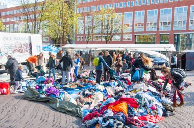 Amsterdam-Nisan 30: Kimliği belirsiz kişi günlük bit pazarı Waterlooplein (Waterloo Meydanı) satışa giysilerle Nisan'da satın 30,2015, Hollanda.