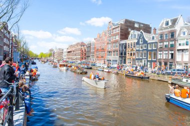Amsterdam-Nisan 27: Yerli halk ve turistler Singel kanal boyunca Kral'ın günü güneşli Nisan günü kutlamak 27,2015. Kral'ın en büyük Festivali Hollanda Kraliyet doğum kutlama günüdür.