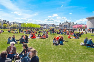 Amsterdam-Nisan 27: Kral'ın gün Nisan insanlar Museumplein dinlenin 27,2015. Museumplein üç müze arasında ortak bir yer: Rijksmuseum, Van Gogh Müzesi ve Stedelijk Müzesi.