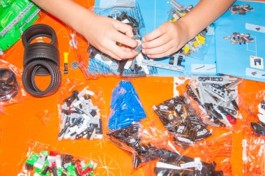 Moskova, Rusya - 7 Kasım 2016: Lego yarış arabası modeli açıklaması ile planlama çocuk eller.
