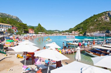 Corfu, Yunanistan-Ağustos 26: Palaiokastritsa plaj kalabalık yerli halk ve turistler, Ağustos'ta kumsalda güneşlenme ile 26,2014 Korfu, Yunanistan. Palaiokastritsa kuzey batısında Korfu ünlü plajları ile bir köydür.