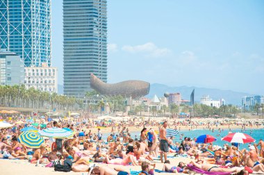 Barcelona-28 Temmuz: Barceloneta Barselona'nın sahilinde, 28 Temmuz 2012 tarihinde tatilcilerin güneşlenmek. İspanya.