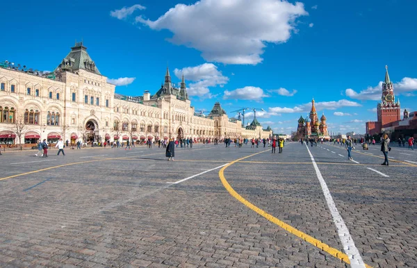 Moskou-maart 23: Rode plein met de Sint-Basiliuskathedraal in de verte, Kremlin aan de rechterkant tijdens de middag, mensen gaan attracties. — Stockfoto