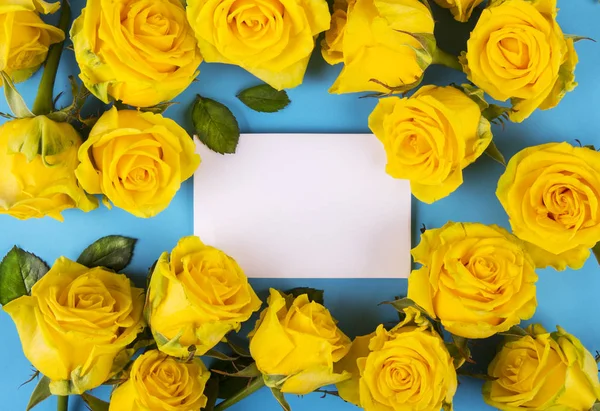 Yellow roses with card on blue background — ストック写真