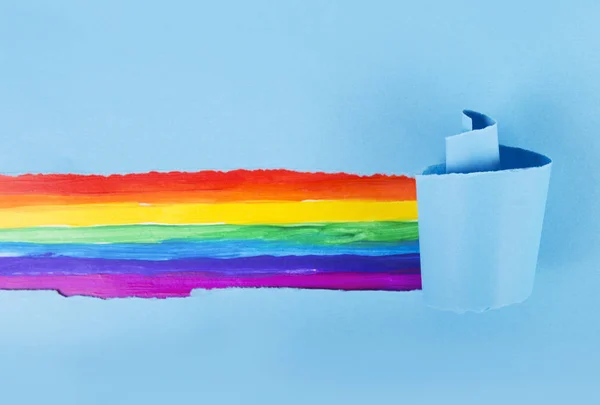 Een regenboog lijn in een gescheurd wit stuk papier — Stockfoto