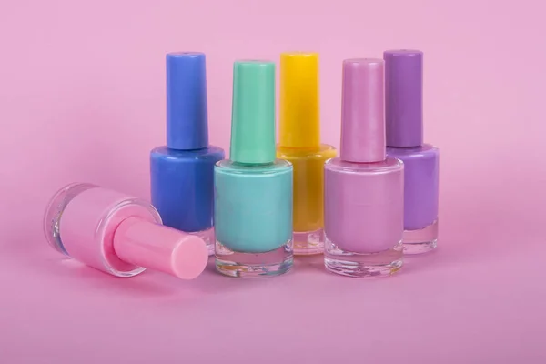 Group of bright nail polishes, on pink background — Stock Photo, Image