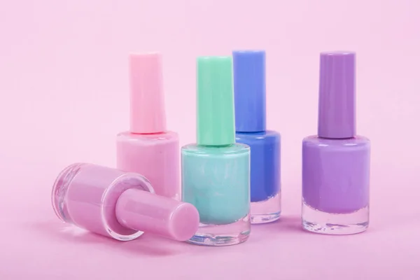 Group of bright nail polishes, on pink background — Stock Photo, Image