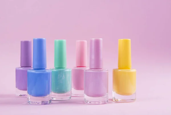 Mnohobarevné laky na nehty na barevném pozadí — Stock fotografie
