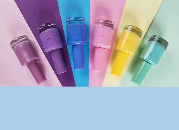 Viele Flaschen Nagellack auf farbigem Hintergrund, Draufsicht — Stockfoto