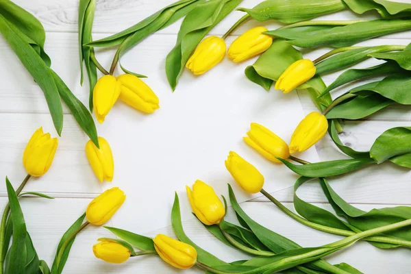 Kytice žlutých tulipánů na dřevěné pozadí. — Stock fotografie
