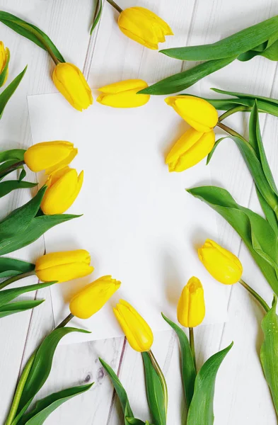 Livro branco para o seu texto e buquê de tulipas amarelas em madeira — Fotografia de Stock