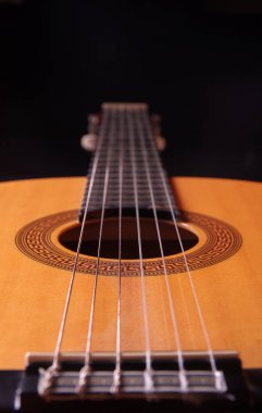 siyah bir zemin üzerine bir akustik gitar parçası