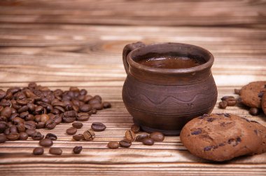 Kil Kupası ahşap bir masa üzerinde kahve çekirdekleri ile