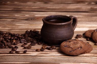 Kil Kupası ahşap bir masa üzerinde kahve çekirdekleri ile